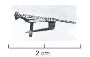 FIB-6068 - Fibule zoomorphe : oiseauargentTPQ : 700 - TAQ : 1000Fibule en forme d'oiseau aux ailes repliées, figuration assez réaliste avec le détail des plumes, sauf le bec qui semble tronqué; système d'articulation avec une bélière rectangulaire comme sur les fibules monétiformes tardives.
