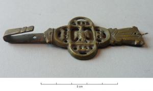 FRT-8002 - Ferret à médaillon figurébronzeTPQ : 1400 - TAQ : 1550Ferret en trois parties : l'attache supérieure rivetée sur l'extrémité de la ceinture, avec unlettre gothique gravée en double trait ; une partie médiane en forme de quadrilobe ajouré, orné d'un volatile (colombe ?) aux ailes déployées ; un lest en forme de tête animale.