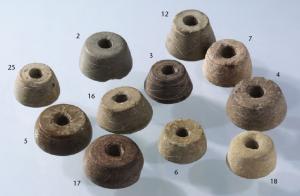 FUS-6002 - FusaïolepierreTPQ : 800 - TAQ : 1200Fusaïole tournée en pierre tendre (stéatite, craie...), de profil tronconique (deux faces parallèles), paroi oblique et parfois légèrement renflée; les filest parallèles ornementaux sont fréquents.