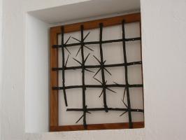 GRF-4001 - Grille de fenêtre
fer
Grille constituée de plusieurs barres de section plate, se croisant à angle droit; les jonctions rivetées sont équipées de sortes d'étoiles en fer venant combler les carrés formés par l'entrecroisement.