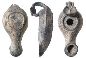 LMP-3020 - Lampe du type d'Ephèse
terre cuite
TPQ : -125 - TAQ : -25
Lampe moulée au réservoir au profil biconique. Anse en anneau d'architecture complexe. Long bec tubulaire à extrémité en large anneau plat, décoré au départ d'une tête barbue. Bandeau avec couronne d'oves en relief. Disque en cuvette plate entouré d'un bourrelet. Un fin bourrelet en relief entoure le trou d'alimentation. 
Base circulaire plate délimitée par un fin bourrelet.