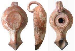 LMP-3021 - Lampe du type d'Ephèse bec fer de lance Howland 49A
terre cuite
TPQ : -125 - TAQ : -25
Lampe moulée, anse en anneau rapportée, constituée de deux boudins soudés. Bandeau décoré d'une couronne de S spiralés. Long bec en fer de lance au dessus plat portant le même décor.  Disque en cuvette plate est limité à l'extérieur par deux fins bourrelets. Un bourrelet  simple entoure le trou d'alimentation.
Base  plate en léger relief, ovale pour équilibrer le poids du bec.