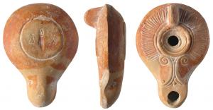 LMP-4100 - Lampe syro-palestinienne planta pedis A D
terre cuite
TPQ : 100 - TAQ : 300
Lampe moulée à anse verticale non percée, bec long en ogive portant deux volutes doubles au départ; frise de longs godrons sur le bandeau, petit disque sans décor; base circulaire plate limitée par un sillon, portant une estampille