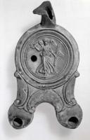 LMP-41297 - Lampe Loeschcke IV : Victoire
terre cuite
TPQ : 25 - TAQ : 75
Lampe à double long bec en ogive à volutes. Médaillon orné d'une victoire tenant couronne et palme. Réflecteur perdu.