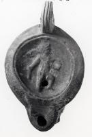 LMP-41314 - Lampe Loeschcke VIII Eros
terre cuite
TPQ : 60 - TAQ : 100
Lampe à bec court défini par un trait horizontal. Médaillon décoré d'un Eros ailé debout tenant un coquillage et une bouteille.