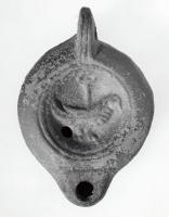 LMP-41319 - Lampe Loeschcke VIII Coq
terre cuite
TPQ : 90 - TAQ : 150
Lampe à bec court défini par un trait horizontal. Médaillon décoré d'un coq.