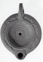 LMP-41324 - Lampe Loeschcke VIII : Cercles
terre cuite
TPQ : 90 - TAQ : 150
Lampe à bec court défini par deux traits latéraux. Médaillon décoré de six cercles concentriques en bas relief. Epaule décorée d'une couronne de myrthe.