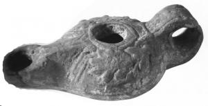 LMP-41471 - Lampe Loeschcke IV variante
terre cuite
TPQ : 200 - TAQ : 300
Lampe allongée avec bec en ogive à volutes. Epaule décorée d'une couronne de myrthe. Anse ajoutée.