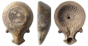 LMP-41516 - Lampe Loeschcke IA
terre cuite
TPQ : -20 - TAQ : 40
Lampe moulée, sans anse. Réservoir circulaire de profil tronconique. Bandeau étroit à trois sillons, penché vers l'intérieur. Disque en profonde cuvette ; décorée d'une rosace à 28 pétales autour de 4 cercles concentriques en relief. Petit canal en V. Bec triangulaire à volutes se poursuivant sous le bec. Base en anneau plat. Restes d'un engobe rouge violacé.