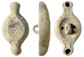 LMP-41538 - Lampe à deux becs diamétralement opposés
terre cuite
TPQ : 100 - TAQ : 300
Lampe moulée, anse centrale verticale à trois sillons sur la tranche.  Réservoir circulaire de profil tronconique. Bandeau penché vers l'extérieur. Disque limité par un sillon concentrique. porte l'anse et deux trous d'alimentation. Becs en bras d'ancre portant un élément décoratif illisible, à volutes simples continuant sous le bec. Base circulaire limitée par un anneau plat. Reste d'engobe beige.