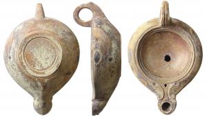 LMP-41540 - Lampe Loeschcke V/B IV 1, médaillon lisse
terre cuite
TPQ : 1 - TAQ : 50
Anse percée à trois sillons. Réservoir circulaire de profil biconvexe assymétrique. Bandeau penché vers l'extérieur. Grand disque profond limité par trois sillons.  Petit bec court en ogive, à volutes simples débutant par deux ocelles sur le bandeau, se poursuivant sous le bec.Trou d'évent. Base circulaire limitée par un anneau plat en léger relief. Restes d'engobe marron rouge.