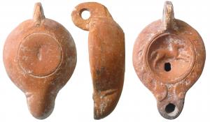 LMP-41541 - Lampe Loeschcke V : cheval, planta pedis
terre cuite
TPQ : 50 - TAQ : 150
Anse percée à deux sillons, moulée avec la lampe. Réservoir piriforme de profil biconvexe asymétrique. Bandeau penché vers l'extérieurporte une couronne de feuilles. Disque circulaire limité par deux sillons. Décor : poulain au galop à droite. Bec long arrondi, à volutes simples se poursuivant sous le bec. Base circulaire limitée par un sillon, plata pedis au centre.  Engobe rouge brique sur toute la lampe.