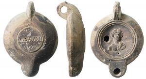 LMP-41570 - Lampe à bec rond limité par un trait : Buste masculin, M NOV IVSTI
terre cuite
TPQ : 120 - TAQ : 180
Lampe moulée, anse verticale percée à deux sillons sur la tranche. Réservoir circulaire à profil biconvexe. Bandeau penché vers l'extérieur, disque en cuvette limitée par deux sillons concentriques. Décor : buste féminin de face (Apollon possible). Bec arrondi limité par un trait droit ponctué aux extrémités. Base circulaire plate en léger relief limitée par un sillon estampillée M NOV IVSTI. Engobe gris marron sur toute la lampe.