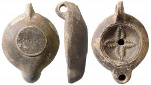 LMP-41582 - Lampe à bec rond limité par un trait : M NOV IVSTI Quatrefeulle
terre cuite
TPQ : 120 - TAQ : 180
Lampe moulée, anse verticale percée à deux sillons sur la tranche. Réservoir circulaire à profil biconvexe. Bandeau penché vers l'extérieur, disque en cuvette limitée par deux sillons concentriques. Décor : quatre feuilles en croix Bec arrondi limité par un trait droit. Base circulaire plate en léger relief limitée par un sillon estampillée M NOV IVSTI. Engobe gris marron  sur toute la lampe.