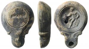 LMP-41589 - Lampe à bec long à volutes doubles : Hercule L M ADIEC
terre cuite
TPQ : 90 - TAQ : 140
Lampe moulée, sans anse. Réservoir circulaire à profil biconvexe asymétrique. Bandeau penché vers l'extérieur. Disque en cuvette limitée par deux sillons concentriques. Décor : Hercule assis sur un rocher, tenant une massue dans sa main gauche et une coupe dans l'autre. Bec arrondi à deux volutes doubles se poursuivant sous la lampe. Base circulaire plate en léger relief limitée par un sillon. Estampillée L.MADIEC. Engobe gris foncé sur toute la lampe.