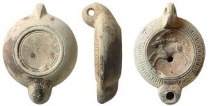 LMP-41609 - Lampe à bec cordiforme : Cervidé
terre cuite
TPQ : 150 - TAQ : 250
Lampe moulée, anse verticale percée à deux sillons sur la tranche. Réservoir circulaire à profil biconvexe. Bandeau penché vers l'extérieur au décor d'oves. Disque en cuvette limitée par deux sillons, cervidé à gauche.  Bec arrondi cordiforme portant un décor de traits en éventail au dessous. Base circulaire plate en léger relief limitée par un bourrrelet et trois  sillons. Petit cercle pointé au centre.  Engobe brun-gris sur toute la lampe.