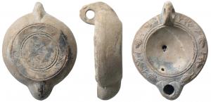 LMP-41612 - Lampe à bec cordiforme
terre cuite
TPQ : 175 - TAQ : 275
Lampe moulée, anse verticale percée à deux sillons sur la tranche. Réservoir circulaire à profil biconvexe. Bandeau penché vers l'extérieur au décor de grappes et feuilles de vigne. Disque en simple cuvette limitée par deux sillons. Bec arrondi cordiforme porte un décor de traits en éventail au dessous. Base circulaire plate en léger relief limitée par un large anneau plat et deux sillons. Petit cercle au centre et trois motifs décoratifs sur l'anneau.  Restes d'engobe gris foncé sur toute la lampe.