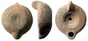 LMP-41617 - Lampe à bec court et décor de globules Planta pedis 
terre cuite
TPQ : 175 - TAQ : 225
Lampe moulée, anse verticale non percée . Réservoir circulaire à profil biconvexe. Bandeau large penché vers l'extérieur orné de trois cercles de globules. Petit disque en simple cuvette limitée par deux sillons. Bec arrondi en trapèze (Deneauve bec J). Base circulaire plate en léger relief limitée par un  sillon porte une planta pedis flanquée d'un delta eet d'un I. Engobe gris sur toute la lampe.