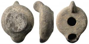 LMP-41634 - Lampe tournée fermée
terre cuite
TPQ : 200 - TAQ : 400
 Anse verticale ronde, pleine, rapportée. Réservoir tourné de profil tronconique. Dessus plat sans délimitation. Bec rond rapporté. Base circulaire plate en relief. Engobe ou émail gris mat sur toute la lampe.