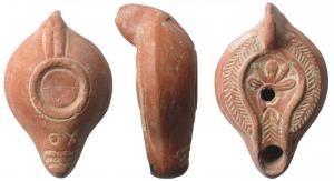 LMP-41661 - Lampe Hayes I : Plante EXO
terre cuite
TPQ : 250 - TAQ : 350
Lampe moulée, anse verticale pleine. Réservoir piriforme de profil biconvexe. Palmes descendantes sur le bandeau.  Disque et petit bec entourés par un bourrelet.: Plante à cinq feuilles rayonnantes sur le disque, palme sur le bec. Base plate limitée par un bourrelet. souligné par deux sillons. double bourrelet rejoignant l'anse Trois bandes d'éléments guillochés sous le bec qui porte  EXO gravé, lisible bec en haut. Engobe rouge orangé.