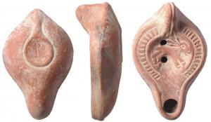 LMP-41669 - Lampe Hayes I : Lièvre P
terre cuite
TPQ : 300 - TAQ : 400
Lampe moulée, anse verticale pleine à un sillon, faisant avec la patère une excroissance caractéristique du type. Réservoir piriforme de profil biconvexe. Stries rayonnantes sur le bandeau limité par un bourrelet. extérieur qui entoure aussi le bec. Disque entouré par un bourrelet interrompu au départ du bec. Lièvre à droite. Base plate à patère en reliefa. Porte un  P gravé. Restes d'engobe rouge brique.