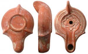 LMP-41678 - Lampe chrétienne , à canal et bec épaulé
terre cuite
TPQ : 350 - TAQ : 600
Lampe moulée, à anse pleine. Réservoir piriforme de profil biconvexe. Décor de  palmes sur le bandeau plat. Disque  limité par un sillon : deux carrés superposés décalés de 45°, aux cadres perlés. Un anneau perlé au centre. Bec long à canal entouré par un bourrelet, épaulé, ouvert sur le disque. Deux excroissances au départ du bec, sur le bord du réservoir. Base circulaire limitée par un bourrelet, souligné par deux sillons intérieurs.  Trois bourrelets la relie à l'anse et au départ du bec. Engobe rouge brique.