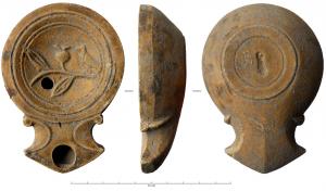 LMP-41886 - Lampe Loeschcke IC : oiseau sur branche
terre cuite
TPQ : 70 - TAQ : 120
Lampe moulée, sans anse. Réservoir circulaire de profil tronconique. Bandeau étroit plat. Disque en profonde cuvette limitée par deux sillons concentriques ; décor oiseau à gauche, posé sur une branche de grenadier, avec feuilles et fruit. Bec triangulaire à deux volutes se poursuivant sous le bec. Base circulaire plate, avec estampille profonde