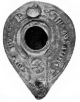 LMP-4193 - Lampe syro-palestinienne tardive 
terre cuite
TPQ : 400 - TAQ : 600
Lampe de type pantoufle. Epaule décorée de lettres arabes (Au nom de Dieu. Bénédiction de Dieu à celui qui l'achète).  Bec intégré dans la lampe. Anse conique.