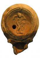 LMP-41956 - Lampe Loeschcke IV : Amour (?)
terre cuite
TPQ : 75 - TAQ : 125
Lampe moulée, sans anse, à bec en ogive et doubles volutes; bandeau lisse, penché vers l'extérieur;  médaillon concave, cerné de trois cercles concentriques, et orné d'un Amour ailé et vêtu, debout.