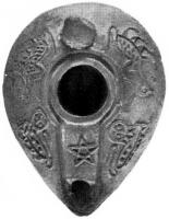 LMP-4195 - Lampe syro-palestinienne tardive 
terre cuite
TPQ : 400 - TAQ : 700
Lampe de type pantoufle. Epaule décorée d'oiseaux.  Bec intégré dans la lampe et surmonté d'un canal, sur lequel se trouve une étoile à 5 branches. Anse conique.