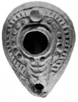 LMP-4196 - Lampe syro-palestinienne tardive 
terre cuite
TPQ : 400 - TAQ : 700
Lampe de type pantoufle. Epaule décorée de points et de rayons en relief.  Bec intégré dans la lampe et surmonté d'un canal, sur lequel se trouve une menorah. Anse conique.