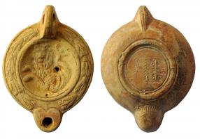 LMP-41986 - Lampe à bec cordiforme : Lion marin
terre cuite
TPQ : 225 - TAQ : 250
Lampe moulée, anse verticale pleine. Réservoir circulaire à profil biconvexe., bandeau penché vers l'extérieur au décor de guirlande de laurier noué. Disque en simple cuvette limitée par deux sillons ; lion marin à gauche, la queue bifide relevée vers le haut.  Bec arrondi cordiforme au dessous strié. Base circulaire plate en léger relief limitée par un bourrelet souligné par deux sillons, et portant un signe incisé (3 palmes verticales). Restes d'engobe rouge sur toute la lampe.