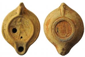 LMP-41991 - Lampe à bec à canal : Diane
terre cuite
TPQ : 80 - TAQ : 150
Lampe moulée, anse verticale forée, à deux sillons. Réservoir circulaire à profil convexe. Bandeau large penché vers l'extérieur, décor moulé (guirlande ?). Disque en cuvette limitée par deux sillons concentriques. Décor : Diane marchant à gauche, brandissant un arc. Bec à canal ouvert sur le disque. Base circulaire plate limitée par un anneau en léger relief. Engobe marron  sur toute la lampe.