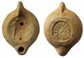 LMP-41993 - Lampe à bec cordiforme : Hermès
terre cuite
TPQ : 150 - TAQ : 250
Lampe moulée, anse verticale non forée; bord légèrement incliné vers l'extérieur et orné d'un galon ; médaillon représentant un hermès à gauche, personnage devant (?);  bec cordiforme, strié en-dessous; base circulaire limitée par un bourrelet et ornée d'une rosette incisée. Argile beige orangé, engobe rouge brique.