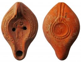 LMP-41996 - Lampe Hayes I : Amour
terre cuite
TPQ : 300 - TAQ : 450
Moulée, anse verticale pleine à un sillon, deux points au départ. Réservoir piriforme de profil biconvexe. Palme descendante stylisée sur le bandeau. Disque et  bec entourés par un bourrelet. Amour à droite. Base concave limitée par un bourrelet souligné par une gouttière. Forme patère avec l'anse. porte un élément en forme de flèche. Engobe rouge orangé.