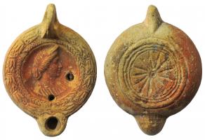 LMP-41997 - Lampe à bec cordiforme : Buste féminin diadémé
terre cuite
TPQ : 225 - TAQ : 250
Moulée, anse verticale percée à deux sillons sur la tranche. Réservoir circulaire à profil biconvexe. Bandeau penché vers l'extérieur au décor de guirlande de laurier noué. Disque en simple cuvette limitée par deux sillons ; buste féminin diadémé à gauche.  Bec arrondi cordiforme. Base circulaire plate en léger relief limitée par un bourrelet et deux sillons. Porte un petit cercle au centre et un décor de traits rayonnants. Restes d'engobe rouge sur toute la lampe.