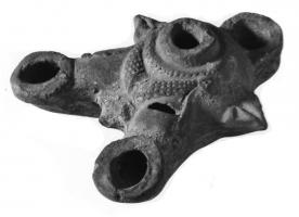 LMP-4211 - Lampe Loeschcke IV à trois becs (variante syrienne)
terre cuite
TPQ : 80 - TAQ : 150
Lampe de Type Loeschcke IV à trous becs en ogive à volutes. La forme de la lampe suggère une tête de taureau à guirlande, d'après des lampes plastiques de type égyptien très répandues.