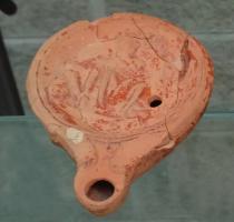 LMP-42294 - Lampe Loeschcke IV : personnage érotique
terre cuite
TPQ : 50 - TAQ : 150
Lampe à bec rond entre deux volutes; disque orné d'un personnage érotique assis de face, jambes écartées. Argile orange-marron, engobe orangée; base plate.