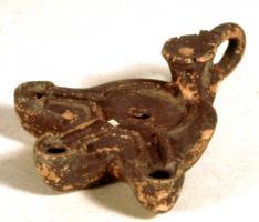 LMP-42316 - Lampe de firme : IANVARI
terre cuite
TPQ : 100 - TAQ : 150
Lampe moulée, ansée ou non : le réservoir circulaire est de profil biconvexe asymétrique; bandeau penché vers l'extérieur portant deux tenons rectangulaires non percés, sur l'axe horizontal. Disque en cuvette profonde bordée par un bourrelet continu. Bec long au petit canal non communiquant avec le disque, chanfeiné sur les côtés. Base circulaire plate en creux limitée par deux anneaux concentriques enfermant l'estampille moulée IANVARI, en relief. Engobe rouge brique peu adhérent.