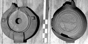 LMP-42486 - Lampe de firme : ROMVLVS
terre cuite
TPQ : 50 - TAQ : 100
Lampe moulée sans anse: le réservoir circulaire est de profil biconvexe asymétrique; bandeau penché vers l'extérieur portant deux ou trois tenons rectangulaires non percés, sur l'axe horizontal. Disque en cuvette profonde bordée par un bourrelet continu. Bec long au petit canal non communiquant avec le disque, chanfreiné sur les côtés. Base circulaire plate en creux limitée par deux anneaux concentriques enfermant la marque moulée ROMVLVS en relief.