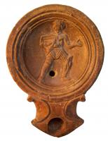 LMP-4290 - Lampe Loeschcke I : Gladiateur
terre cuite
TPQ : 1 - TAQ : 50
Lampe ronde à large bec en enclume, à volutes légèrement
saillantes. Large médaillon légèrement concave, défini par quatre fins anneaux concentriques. Epaule très étroite, plate. Base plate entourée d’un anneau en relief.
