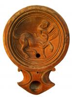 LMP-4291 - Lampe Loeschcke I : Centaure
terre cuite
TPQ : 1 - TAQ : 50
Lampe ronde à large bec en enclume, à volutes légèrement saillantes. Large médaillon légèrement concave, défini par quatre fins anneaux concentriques. Epaule très étroite, légèrement convexe. Base plate entourée d’un anneau en relief.