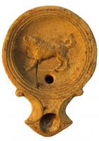 LMP-4302 - Lampe Loeschcke I : Chien
terre cuite
TPQ : 50 - TAQ : 150
Lampe à bec à enclume et volutes latérales; disque orné d'un chien à gauche. Argile noisette, engobe orange foncé à marron foncé; base plate entourée d'un anneau en relief.
