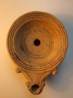 LMP-4309 - Lampe Loeschcke IV
terre cuite
TPQ : 50 - TAQ : 150
Lampe à bec en ogive et volutes latérales; disque vierge. Argile noisette, engobe orange foncé à marron foncé; base plate entourée d'un anneau en relief.