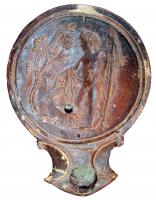LMP-4382 - Lampe Loeschcke I : Dionysos
terre cuite
TPQ : 120 - TAQ : 250
Lampe à bec à enclume; disque orné de Dionysos-berger debout, face à un arbre de vigne. Argile orange, engobe orange; base plate.