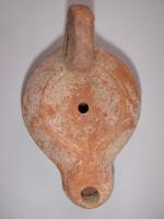 LMP-4605 - Lampe Loeschcke IV 
terre cuite
TPQ : 50 - TAQ : 150
Lampe ronde à long bec en ogive. Disque vierge. Demi-volutes sur le bec. Argile noisette, engobe orange.