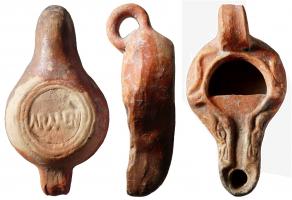 LMP-4720 - Lampe de firme : ARMEN
terre cuite
TPQ : 100 - TAQ : 300
Anse en anneau rapporté. Réservoir circulaire de profil biconvexe asymétrique. Bandeau penché vers l'extérieur porte deux tenons rectangulaires rainurés, non percés et une représentation  de serpents, possible. Disque en cuvette profond bordé par un bourrelet qui se poursuite sur le bec le long d'un étroit canal et entoure le méplat. Le disque est ouvert après démoulage sur la moitié supérieure.  Base circulaire plate en creux limitée par deux anneaux concentriques enfermant la marque ARMEN  en relief, se lisant bec en haut. Restes d'un engobe rouge brique sur toute la lampe ; base réservée.