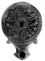 LMP-4855 - Lampe Loeschcke I : Frise d'armes
terre cuite
TPQ : -20 - TAQ : 25
Lampe ronde sans anse,  à large bec en enclume encadré de volutes. Médaillon décoré d'une frise d'armes de gladiateurs.