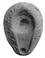 LMP-5057 - Lampe en forme d'amandeterre cuiteTPQ : 600 - TAQ : 700Lampe en forme d'amande, anse en tenon, réservoir creusé d'une dépression lisse avec un petit trou de remplissage centré, et relié au trou de mèche par un canal triangulaire; sur les épaules, motif moulé : ligne brisée.