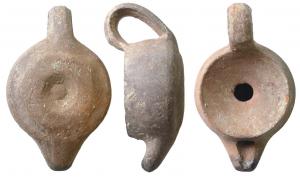 LMP-6088 - Lampe syro-palestinienne tournéeterre cuiteTPQ : 600 - TAQ : 800Tournée, Réservoir circulaire de profil droit. Anse en ruban à pans relie le rebord supérieur au rebord inférieur. Dessus en grande cuvette profonde au petit trou d'alimentation. Bec rapporté, en tenon conique relevé. Base en anneau en relief estompé, bouton au fond d'une petite cuvette centrale.